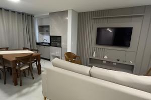 a living room with a couch and a table and a tv at Edificio Elegance in Foz do Iguaçu +28 photos