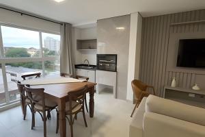 a kitchen and living room with a table and a couch at Edificio Elegance in Foz do Iguaçu
