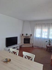 a living room with a television and a fireplace at Casa R in Sesimbra
