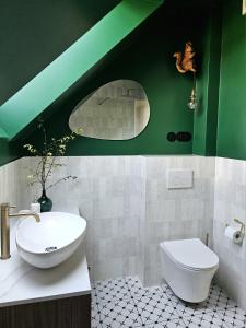 a green and white bathroom with a sink and a toilet at Apartamenty Klikuszówka in Nowy Targ +13 photos