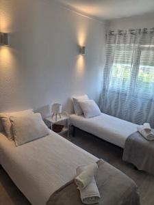 a room with two beds and a window at Casa R in Sesimbra