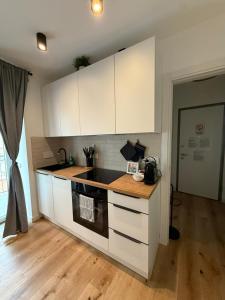 a kitchen with white cabinets and a counter top at 11 Apartaclean Cancellieri in Trieste +14 photos