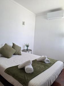 a bedroom with a bed with towels on it at Casa R in Sesimbra +14 photos