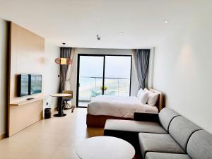 a hotel room with a bed and a couch at The Cam Ranh Oceanview Resort in Cam Ranh