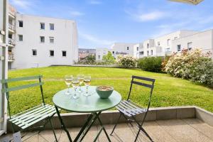 a table with wine glasses and two chairs on a patio at T2 moderne avec terrasse, central et calme in Saint-Herblain +17 photos