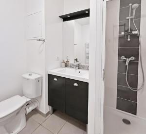 a bathroom with a toilet and a sink and a shower at T2 moderne avec terrasse, central et calme in Saint-Herblain