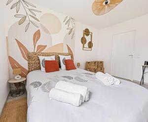 a white bedroom with a large bed with towels on it at T2 moderne avec terrasse, central et calme in Saint-Herblain