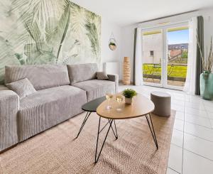 a living room with a couch and a table at T2 moderne avec terrasse, central et calme in Saint-Herblain
