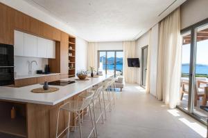 a kitchen with a long counter and chairs at Dawn Milos in Pollonia