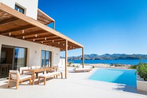 a villa with a pool and a table and chairs at Dawn Milos in Pollonia