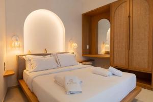 a bedroom with a large white bed with two mirrors at Dawn Milos in Pollonia +56 photos