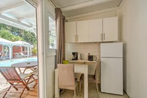 a kitchen with a refrigerator and a table with chairs at Location Dampierre in Le Gosier