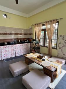 a dining room with a table and a kitchen at inoru house in Khairāni