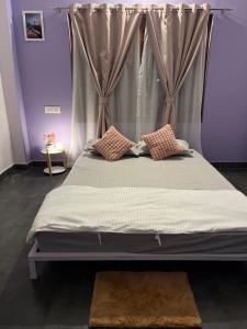 a bed with two pillows on it in a room at inoru house in Khairāni