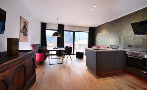 cocina y sala de estar con mesa y sillas en Antonius Natur Apartment - kinderfreie Unterkunft en Lavant