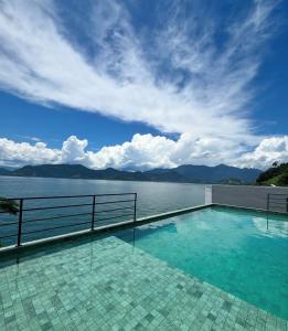 a swimming pool with a view of the water at Refúgio da Lagoa azul in Angra dos Reis
