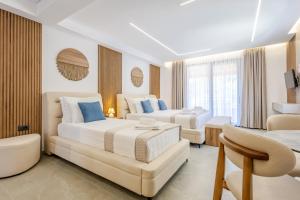 ein Hotelzimmer mit zwei Betten und einer Couch in der Unterkunft Crystal Blue Hotel, Barbati, Corfu in Barbati
