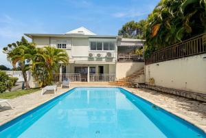 a swimming pool in front of a house at Location Dampierre in Le Gosier
