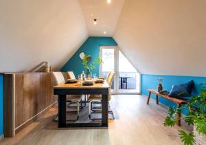 a dining room with a table and blue walls at Le Patio - à 20 minutes d'Europa-Park in Rhinau