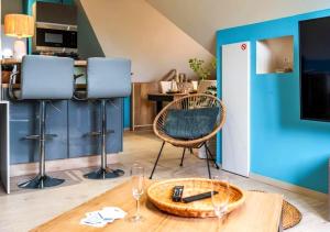 a living room with a table and a blue wall at Le Patio - à 20 minutes d'Europa-Park in Rhinau