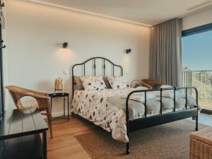 a bedroom with a bed and a balcony at Bungalows da Travanca in Arcos de Valdevez