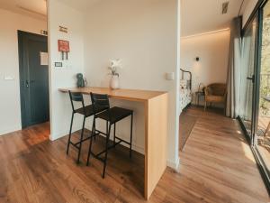a kitchen with a counter and two stools in a room at Bungalows da Travanca in Arcos de Valdevez