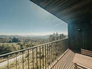 a balcony with a bench and a view of the mountains at Bungalows da Travanca in Arcos de Valdevez +4 photos