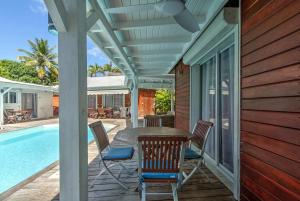 a patio with a table and chairs next to a pool at Location Dampierre in Le Gosier