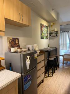 a kitchen with a refrigerator and a table in it at Verdon Parc condominium in Davao City
