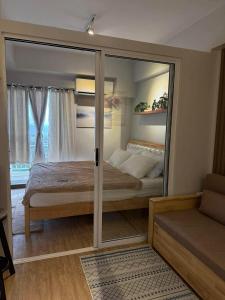 a bedroom with a bed and a large mirror at Verdon Parc condominium in Davao City