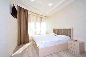 a white bedroom with a large bed and a window at Elite & Grand Luxury Hotel Apartments in Central Yerevan, By Opera and Northern Avenue in Yerevan