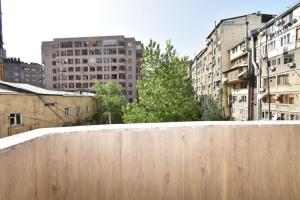 a wooden fence in a city with tall buildings at Elite & Grand Luxury Hotel Apartments in Central Yerevan, By Opera and Northern Avenue in Yerevan