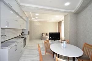 a kitchen and living room with a table and chairs at Elite & Grand Luxury Hotel Apartments in Central Yerevan, By Opera and Northern Avenue in Yerevan