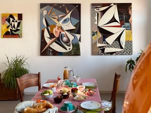 a table with food and art on the wall at Hatablak Boutique Guesthouse in Köveskál in Köveskál