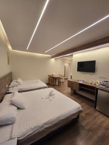 a bedroom with two beds and a flat screen tv at nova pyramids inn in Cairo