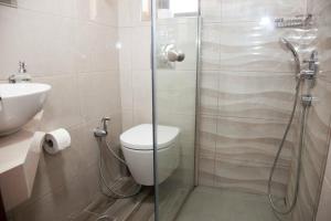 e bagno con doccia, servizi igienici e lavandino. di Sunny Suites a Maleme