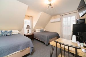 a bedroom with two beds and a tv and a window at The Whitetail Inn and Suites- Lincoln in Lincoln