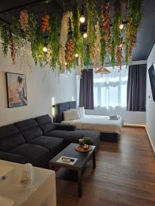 a living room with a couch and a bed at Botanica Noir Jacuzzi Valaoritou in Thessaloniki
