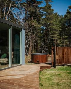 a modern house with a wooden deck and glass at Üleoja Pesa in Kloogaranna