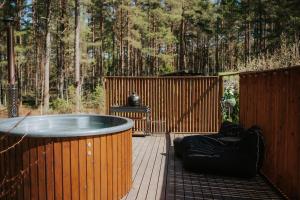 a hot tub on a wooden deck with a fence at Üleoja Pesa in Kloogaranna +15 photos