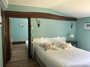 a bedroom with a large white bed with blue walls at Logis Domaine du Prieuré in Tonnay-Boutonne
