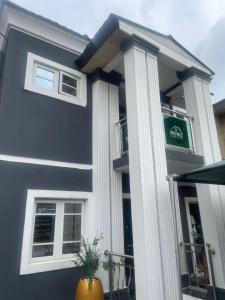 a blue building with columns and a green sign on it at Muniz Apartments in Lagos
