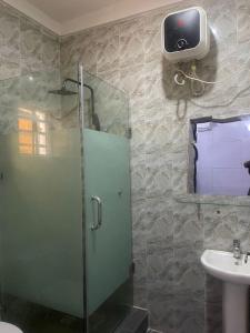 a bathroom with a glass shower and a sink at Muniz Apartments in Lagos +19 photos