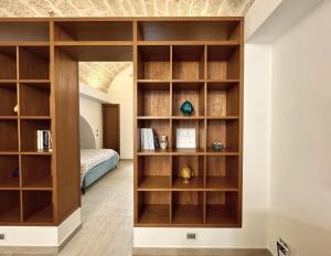 a room with wooden bookshelves and a bed at I quattro Pumi in Mola di Bari