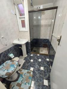 a bathroom with a shower and a toilet and a sink at Pousada recanto das ondas in Macaé