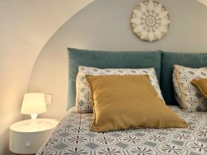 a bedroom with a bed with a pillow and a clock at I quattro Pumi in Mola di Bari