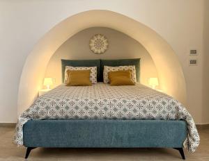 a bedroom with a large bed with an arched ceiling at I quattro Pumi in Mola di Bari
