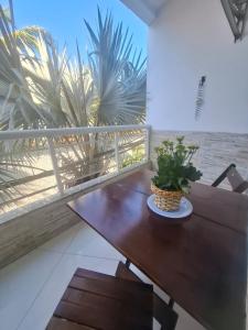 a table with a plant on a balcony with palm trees at POUSADA PARAISO da BARRA DA TIJUCA in Rio de Janeiro