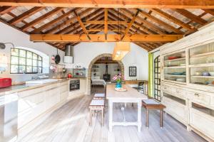 a kitchen with wooden ceilings and a table and chairs at Holiday House La Teja in Facinas