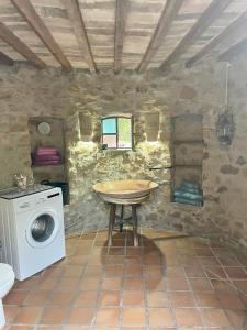 a bathroom with a washing machine and a table at Holiday House La Teja in Facinas